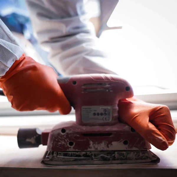 Orange nitrile glove in workshop sanding application